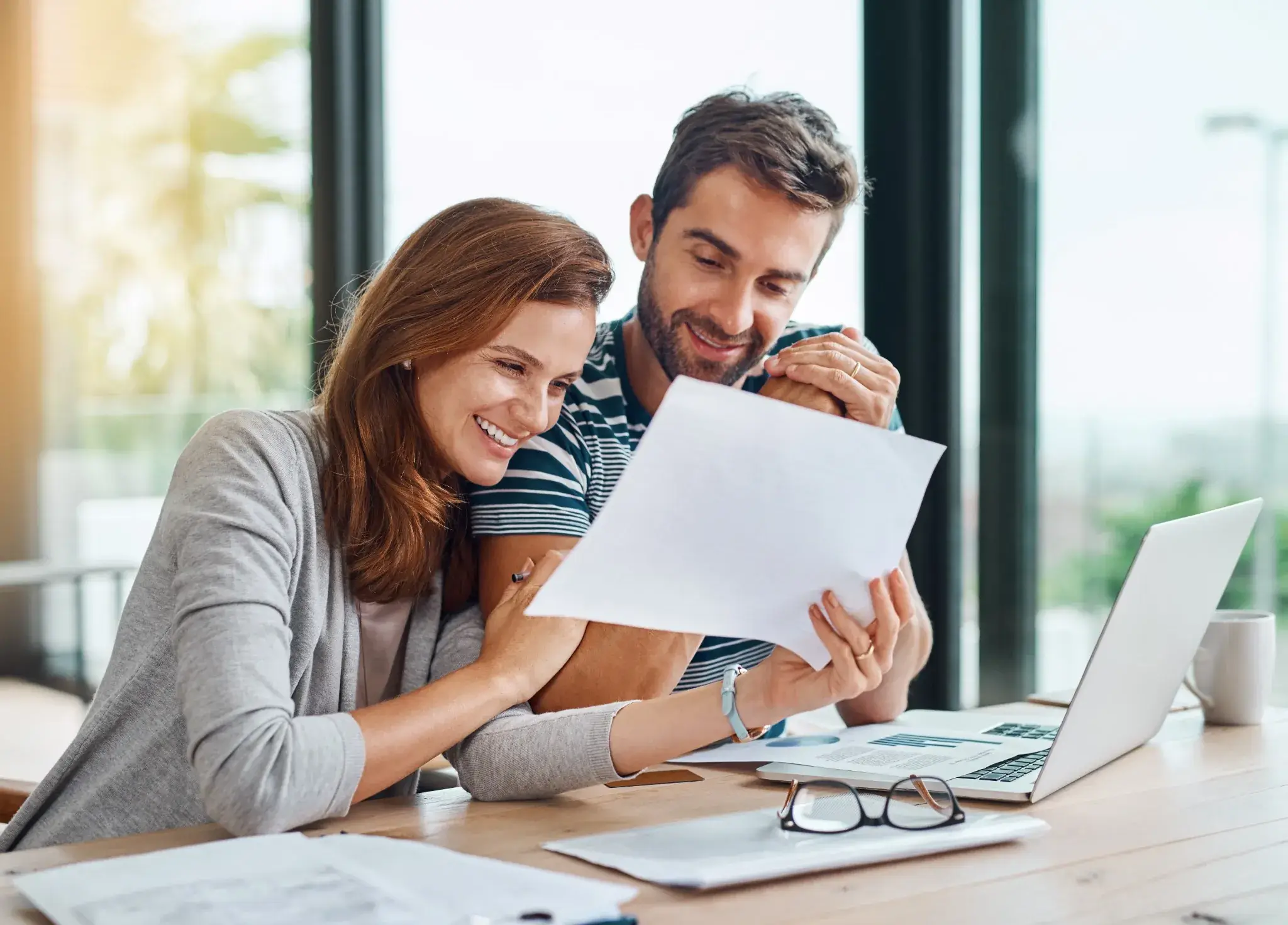 Couple reviewing financial documents together, representing retirement tax planning strategies and financial decision-making
