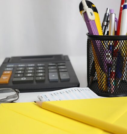 Calculator, notepad and reading glasses on a desk used for retirement income planning