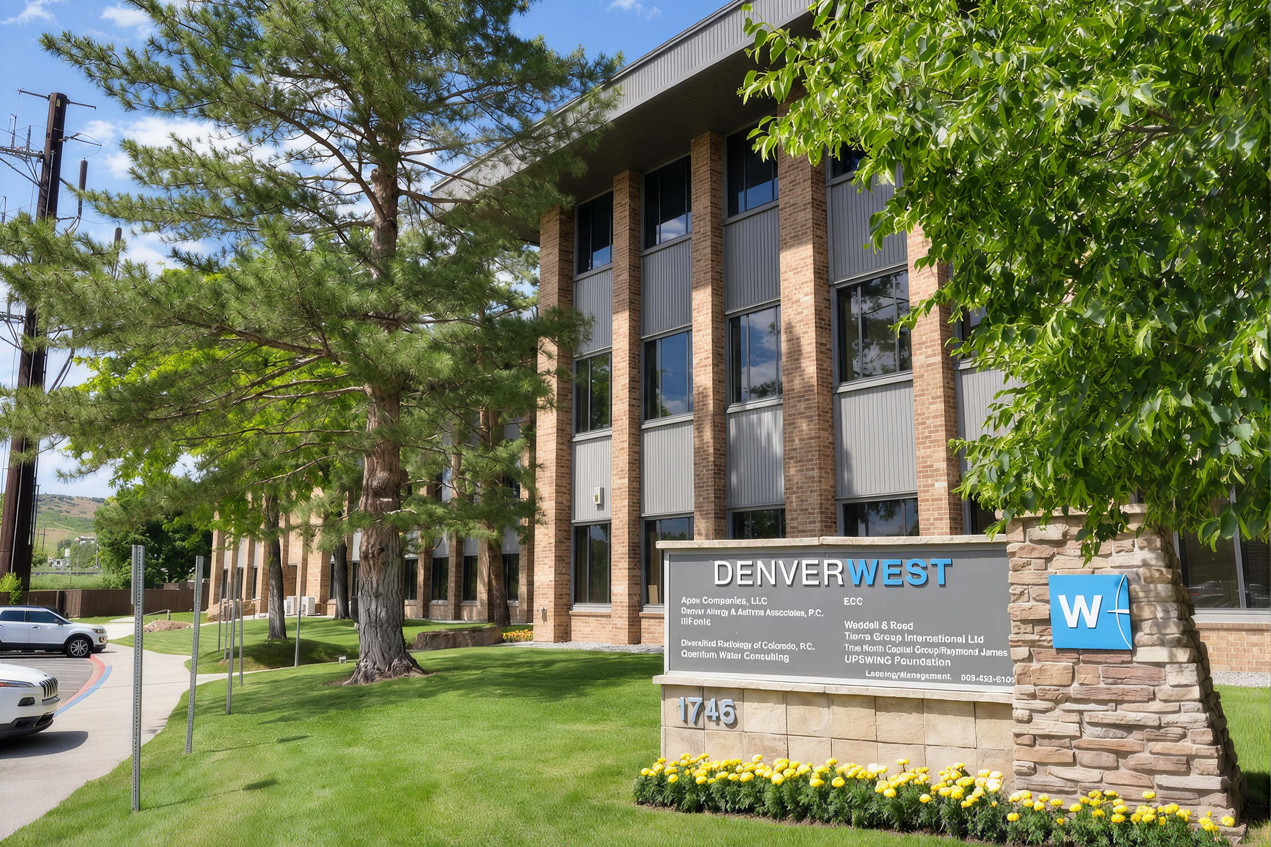wealthclarity-investment-management-hero-mobile Modern suburban office building with landscaped grounds and mature pine trees