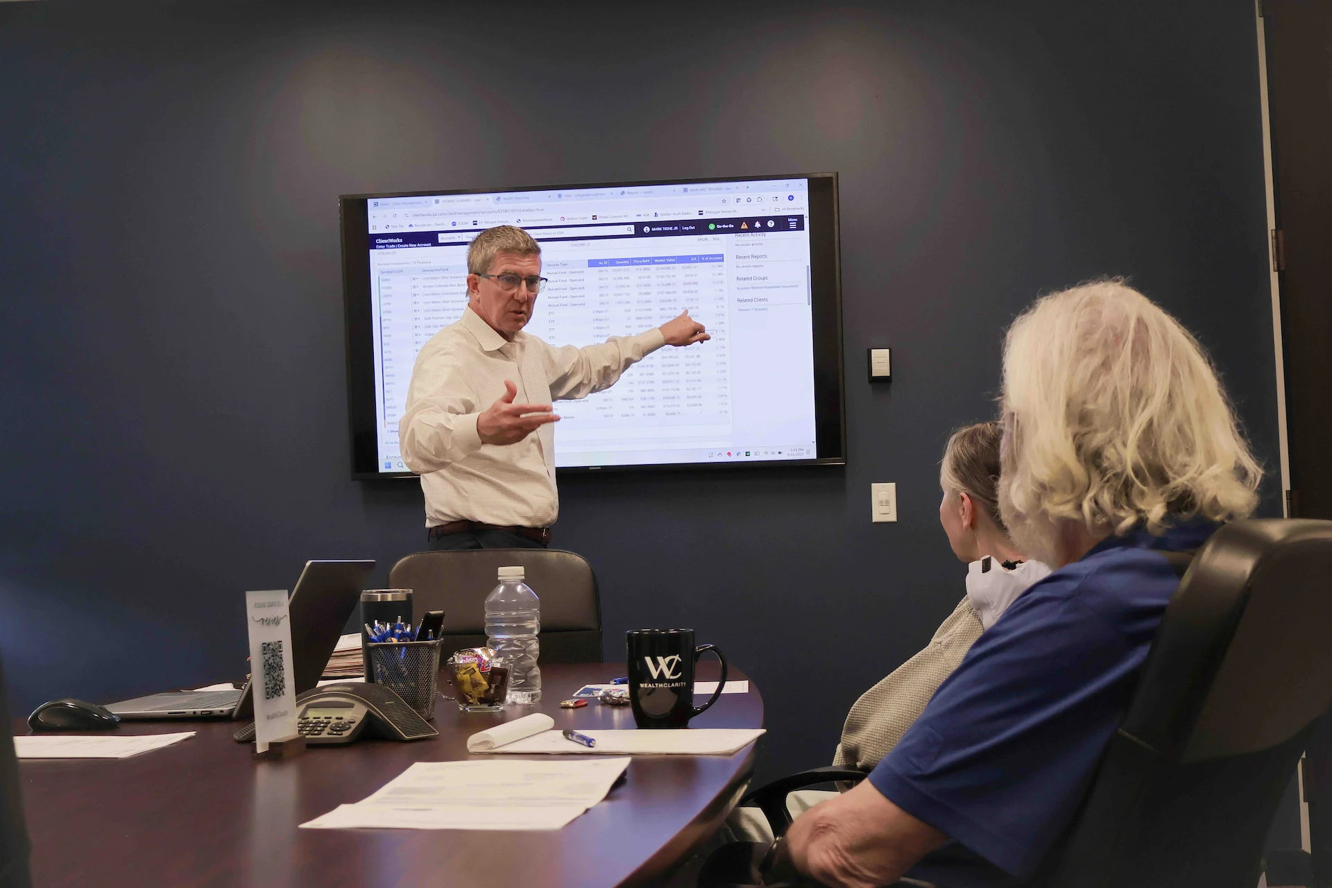 WealthClarity financial advisor presenting to two clients at a conference table during an estate planning review.